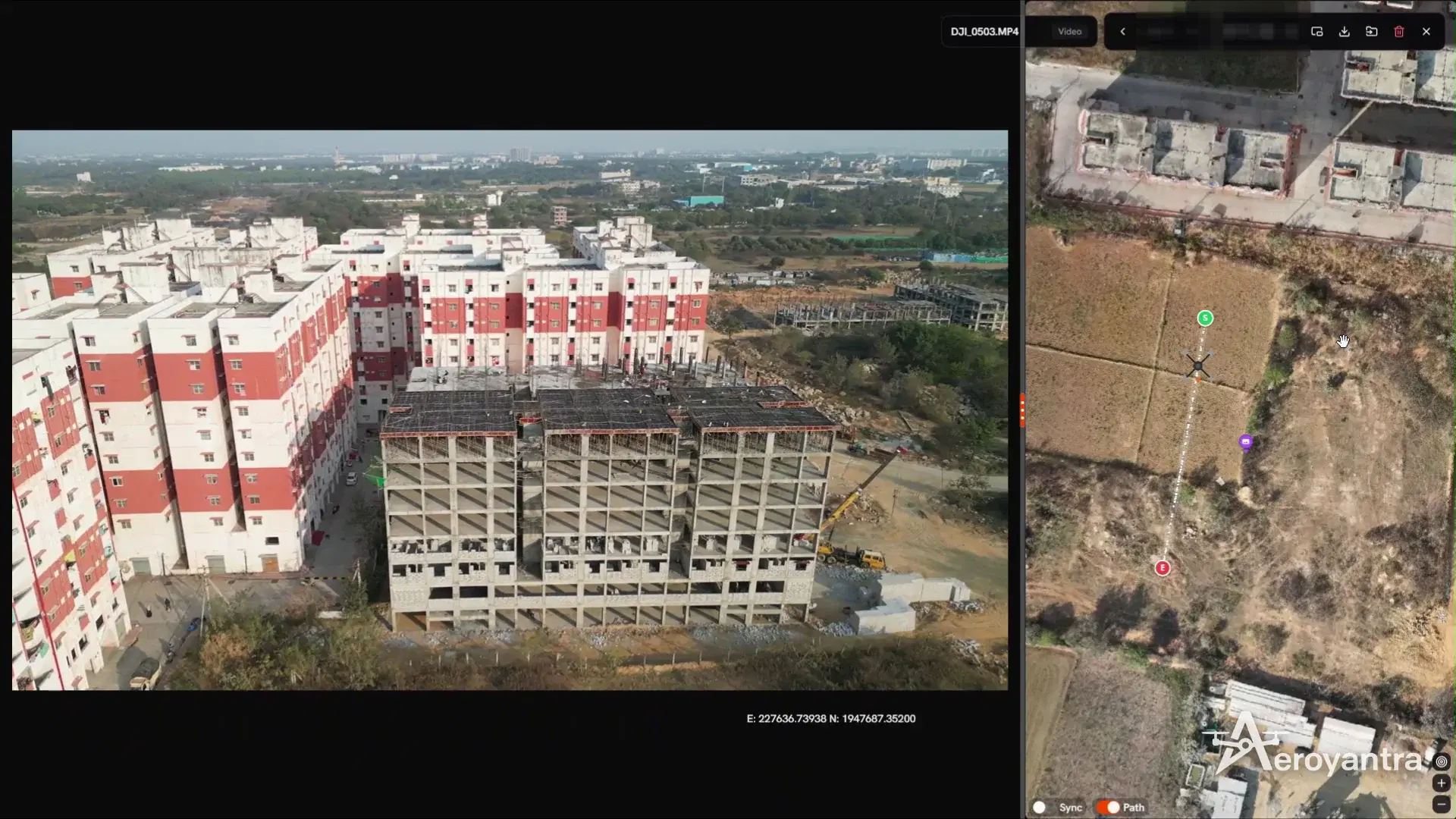Oblique drone video frame of apartment towers under construction beside the drone's flight path on the site map